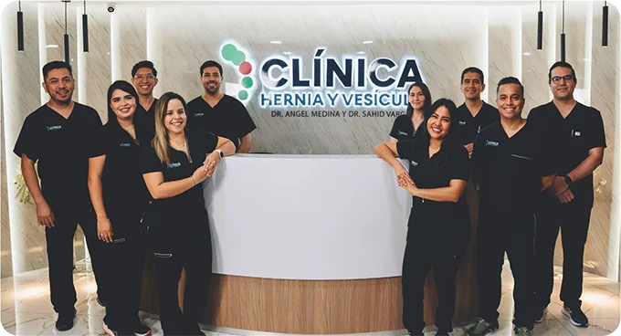 Equipo médico del Instituto de Vesícula Biliar frente al letrero de la clínica